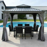 NatureScape Living's gray 13x13 Hardtop Gazebo with curtains covers a black dining set beside a swimming pool.