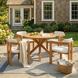 A 5-piece Acacia Wood Patio Set, a round dining table and four chairs with beige cushions, sits on a striped outdoor rug.