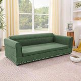 An elegant, modern oversized green linen dog sofa bed with a tufted back and silver nailhead trim.
