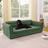An elegant oversized green linen fabric dog sofa bed with rolled arms and nailhead trim, a black dog resting comfortably.