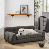 A white dog relaxes on a dark gray, tufted Elegant & Comfortable Large Dog Sofa Bed by NatureScape Living in a cozy room.