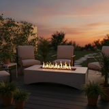A NatureScape Living rectangular propane fire pit table with a modern minimalist design, surrounded by outdoor furniture at sunset.