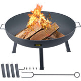 A VEVOR 34-inch round carbon steel fire pit bowl with a blazing wood fire, showing its legs, poker, and hardware.