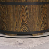 A portable Smokeless Fire Pit, featuring dark wood with rich grain and black metal bands, sits on a grey concrete patio.