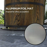 A NatureScape Living Smokeless Fire Pit, crafted from wood, sits on a silver fireproof aluminum foil mat on a patio.