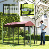A spacious NatureScape Living walk-in dog kennel with a dark frame, maroon roof, and rotating bowl stands on grass.