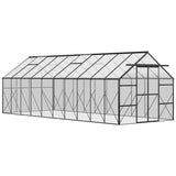 A NatureScape Living Walk-in Greenhouse Kit with a black aluminum frame, clear polycarbonate panels, a pitched roof, and vents.