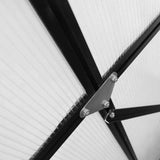 Close-up of a NatureScape Living aluminum greenhouse's sturdy black frame, translucent polycarbonate panels, and bolted metal brace.