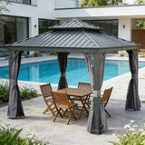 A NatureScape Living 13x13 Hardtop Gazebo with a grey galvanized steel roof, curtains, and wooden patio furniture by a pool.