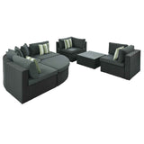 The 7 Piece Wicker Sofa Set features dark brown woven wicker, gray cushions, striped accent pillows, and a glass-top table.