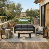 A 4-piece Aluminum Frame Outdoor Sofa set featuring dark grey cushions and wood accents, situated on a deck by a pool.