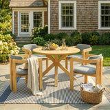 NatureScape Living's 5-piece acacia wood round patio dining set with gray cushions on a striped rug, a Wayfair magazine nearby.