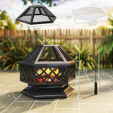 A black hexagonal 18-inch metal wood-burning fire pit with mesh lid, cooking grate, and poker on a patio.