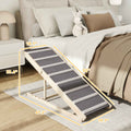 NatureScape Living's adjustable foldable pet ramp, featuring a light wood frame and grey steps, helps dogs access a bed.