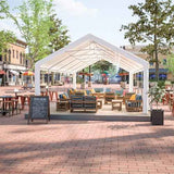 NatureScape Living's 16x32FT Heavy Duty Party Tent provides an elegant outdoor escape, sheltering wooden patio furniture in a paved plaza.