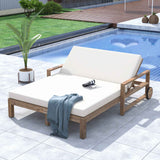 A TREXM Poolside Daybed in farmhouse wooden style, with white cushions and wheels, sits on a tiled patio by a pool.