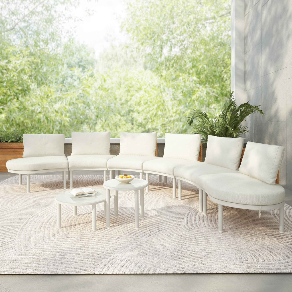 A beige TOPMAX 8-piece half moon outdoor patio sectional sofa with round tables on a textured rug in a lush garden setting.