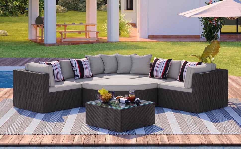 A NatureScape Living GO 7-piece outdoor wicker sofa set with beige cushions, striped pillows, and a coffee table on a deck.