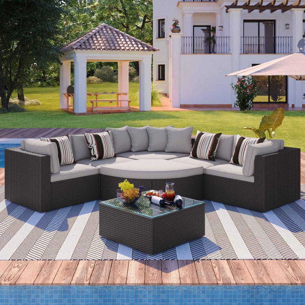 NatureScape Living's GO 7-piece brown wicker sofa set with beige cushions and striped pillows on a wooden deck by a pool.