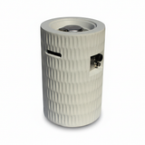 A modern light grey cylindrical propane patio fire pit with a textured surface, top burner, and side controls.
