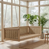A TOPMAX outdoor wood swing bed with rattan sides hangs in a bright sunroom with large potted plants.