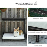 A corgi relaxes on NatureScape Living's Wicker Dog House, a raised rattan puppy bed with a white cushion, sloping roof, and elevated design.