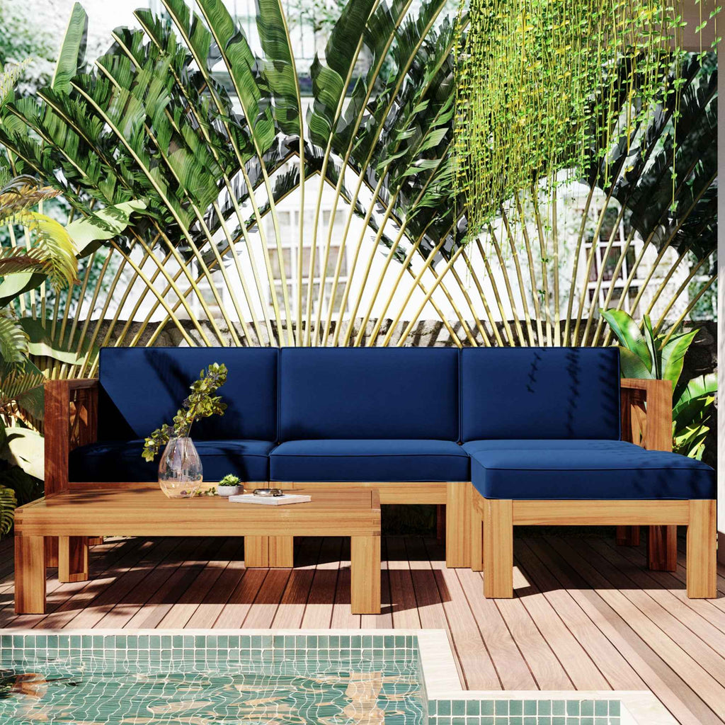A TOPMAX 5-piece wood patio sectional with blue cushions and coffee table on a deck by a pool, surrounded by tropical plants.