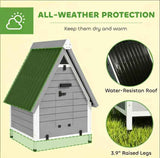 NatureScape Living's grey wooden pet house, with a green corrugated roof, offers all-weather protection from its water-resistant design and raised legs.